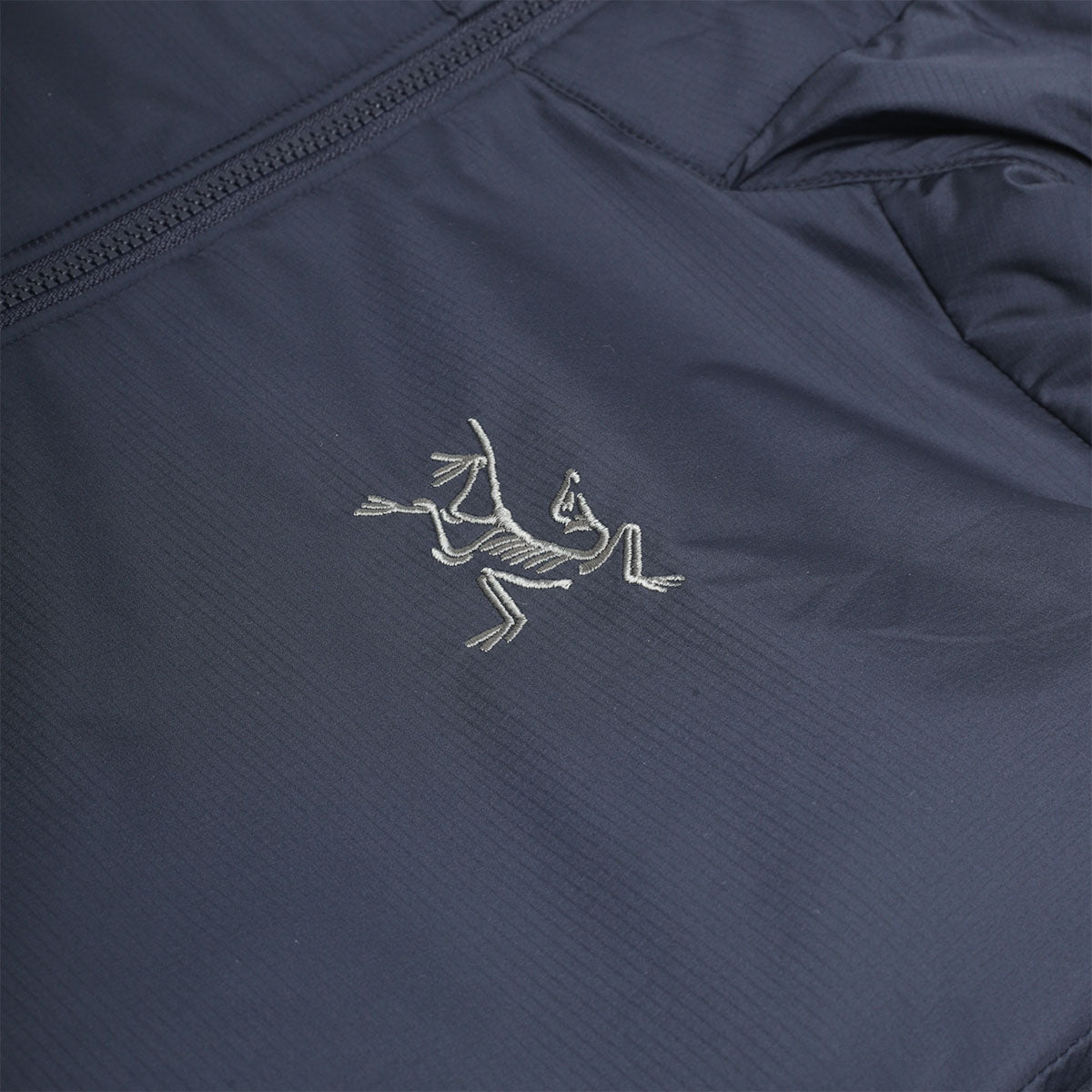 Embroidered Arc'teryx bird logo on navy chest
