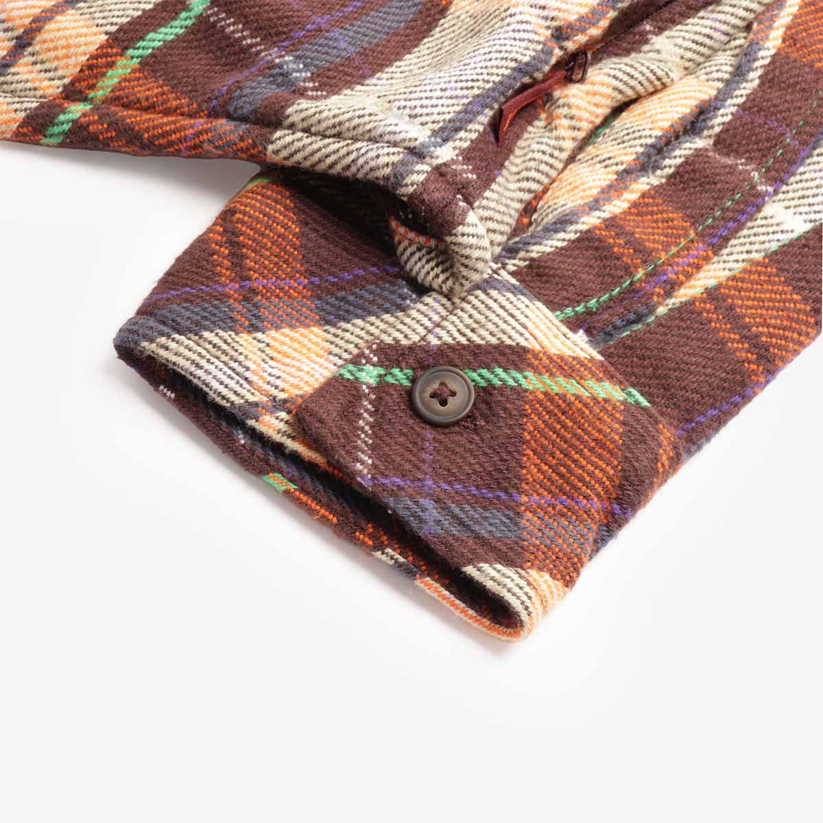 Buttoned cuff detail on rust check flannel