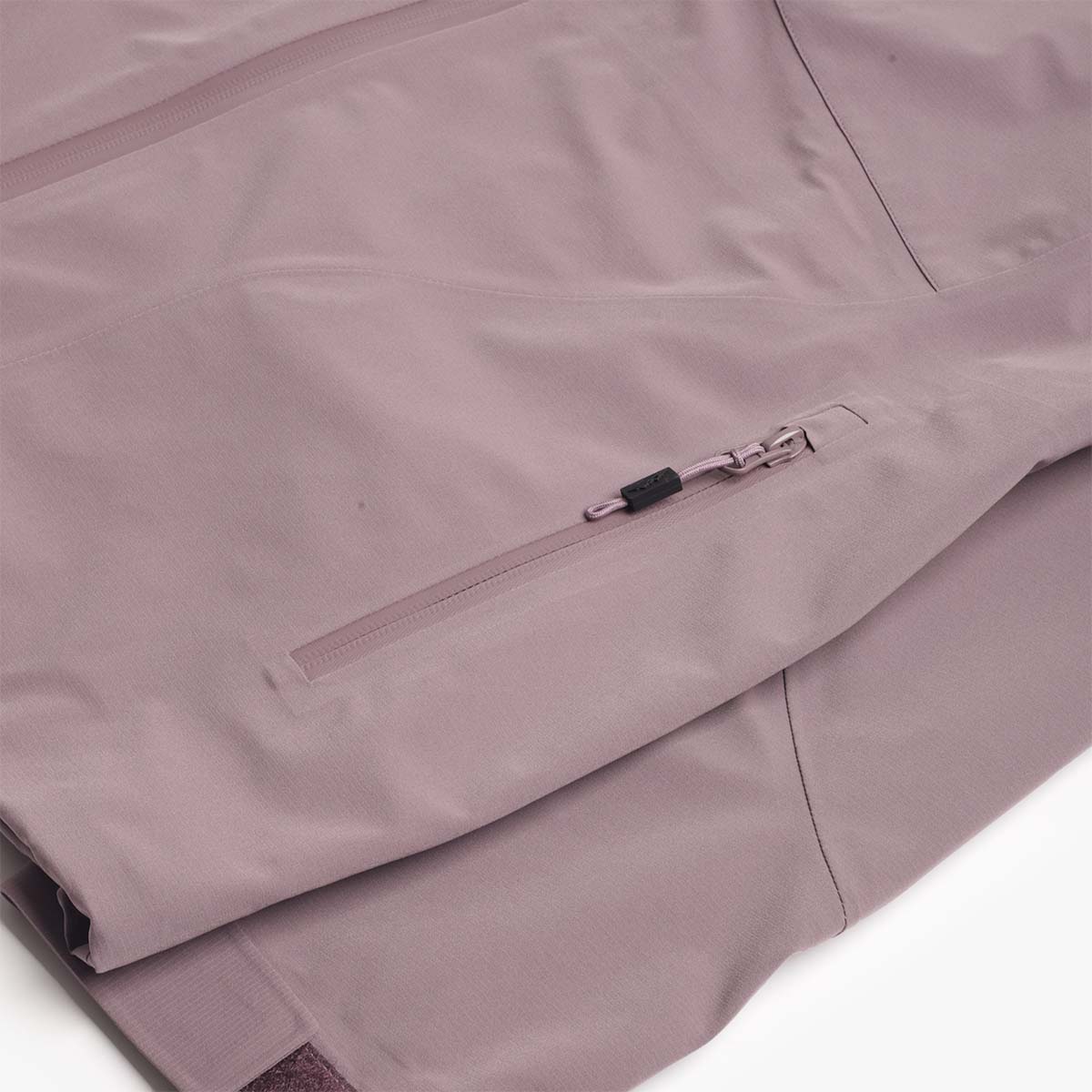 Hem and zip pocket detail, plum Trek shell jacket