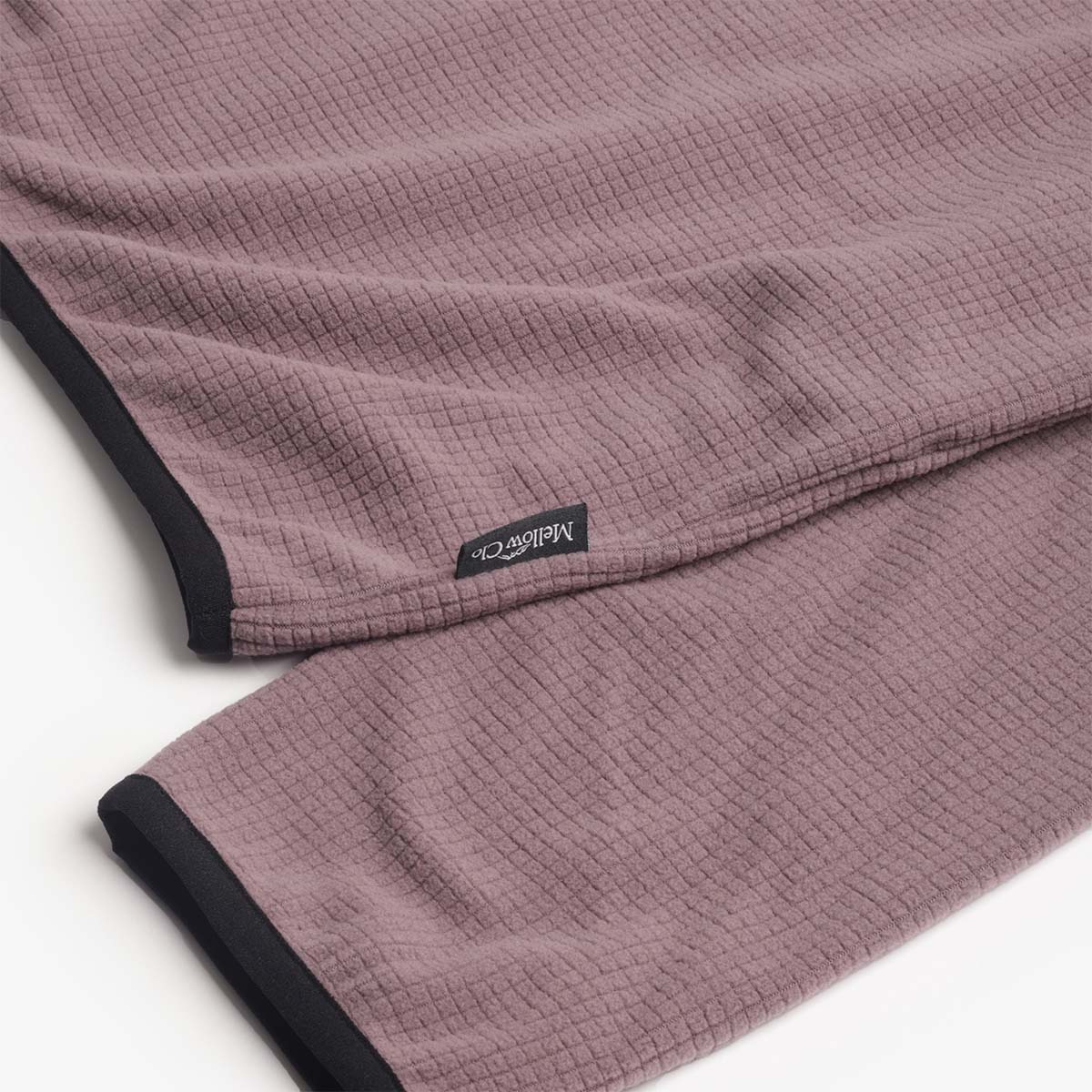 Woven Mellow Clo label on the plum fleece hem