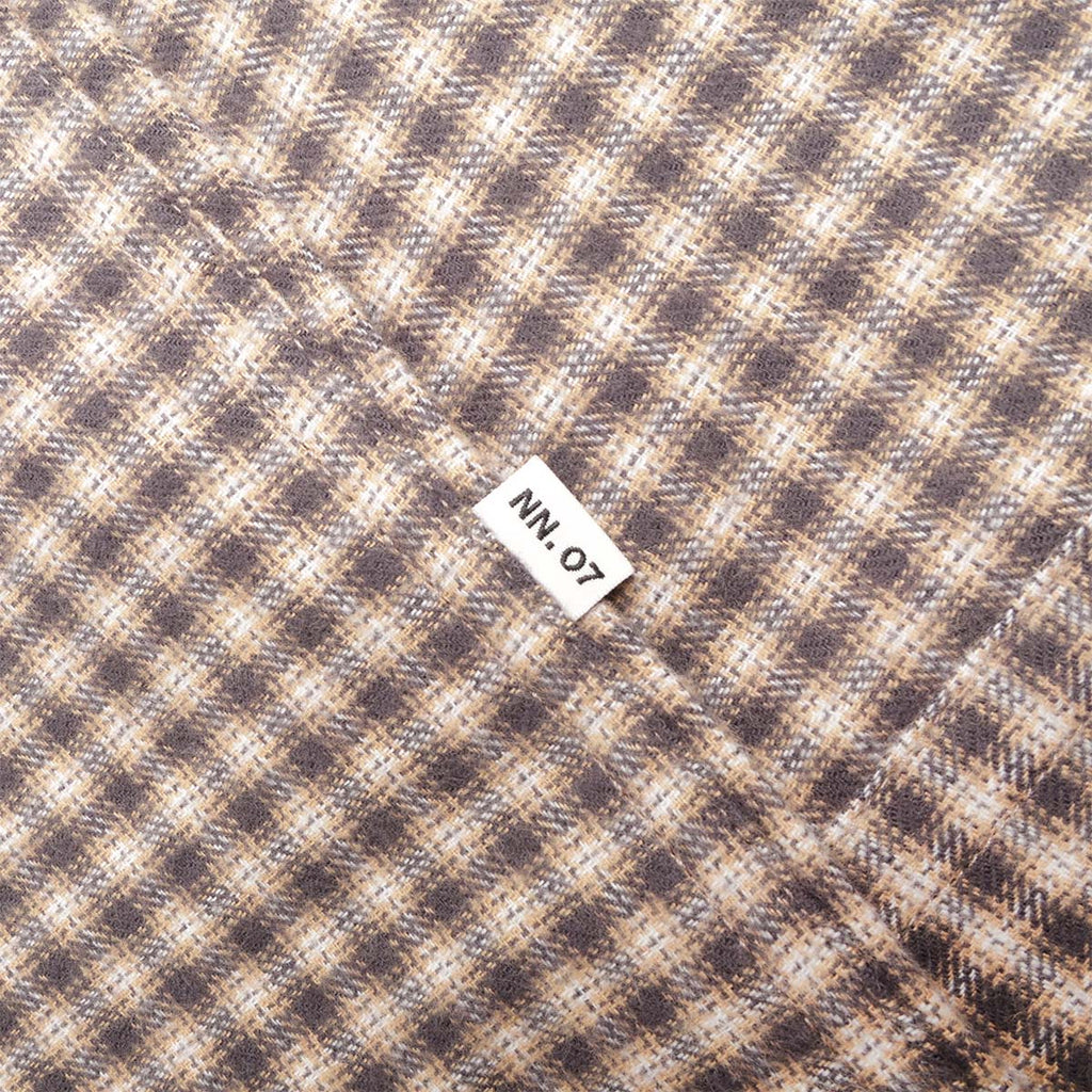NN.07 woven label on sand check flannel
