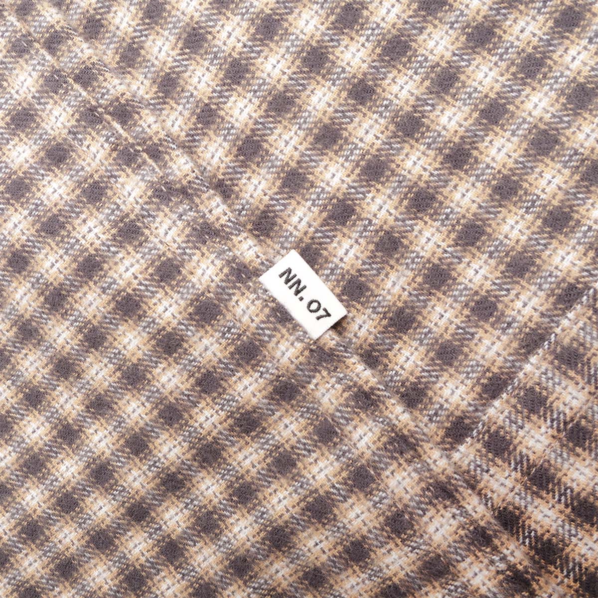 NN.07 woven label on sand check flannel