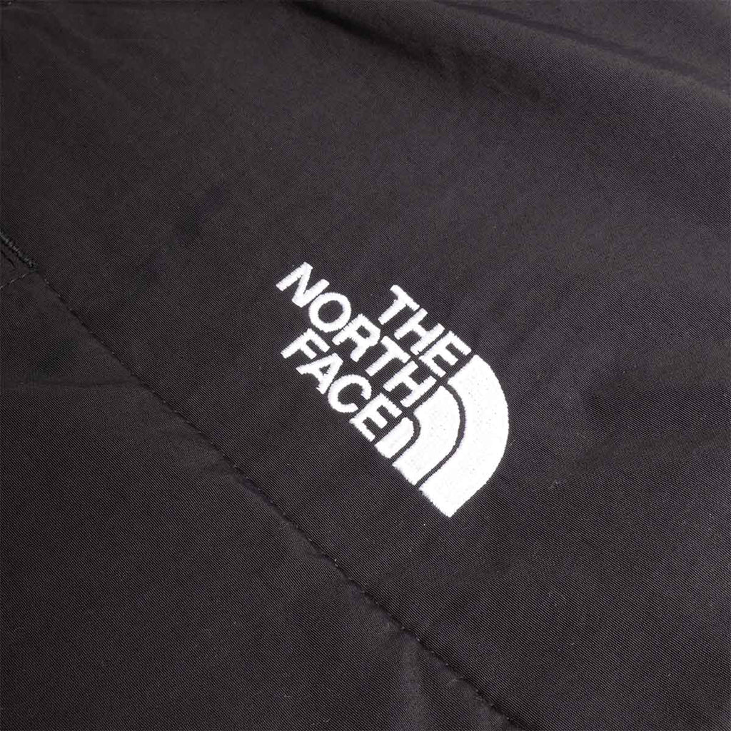 White The North Face logo on black nylon shoulder panel