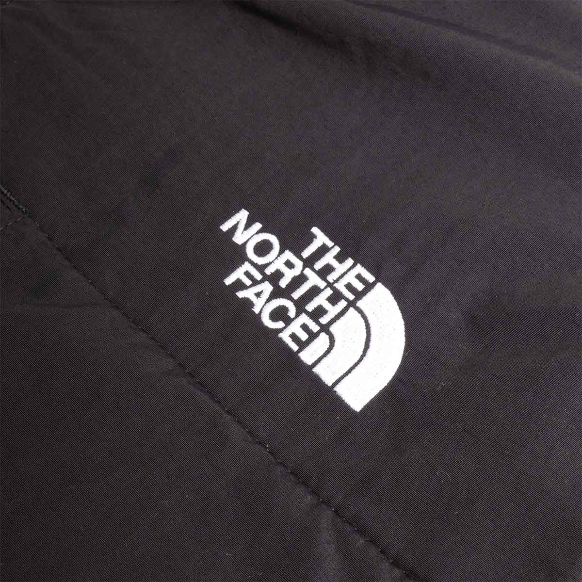 White The North Face logo on black nylon shoulder panel